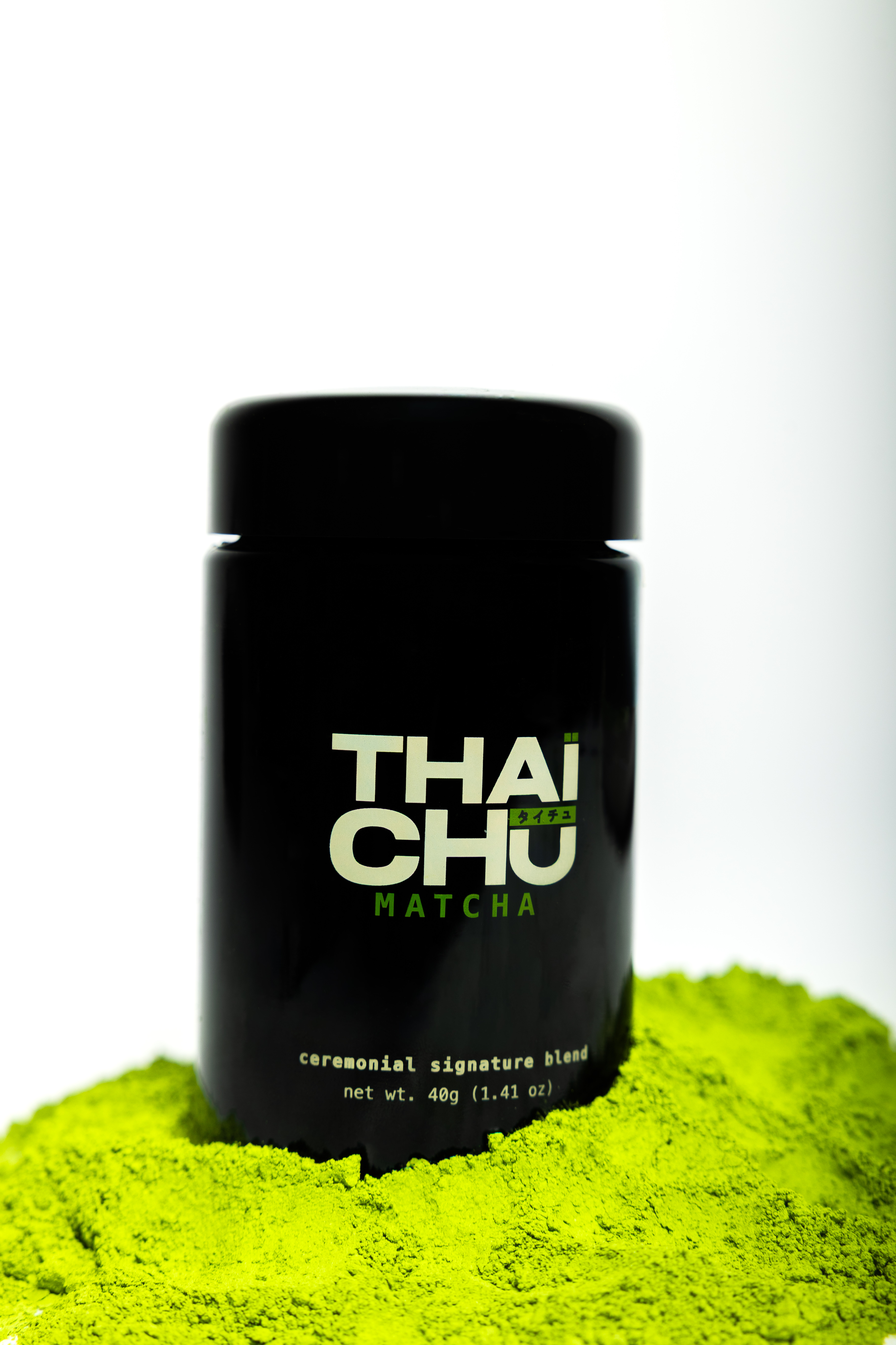 THAÏCHŪ Ceremonial Signature Blend — 40g black glass jar on matcha powder